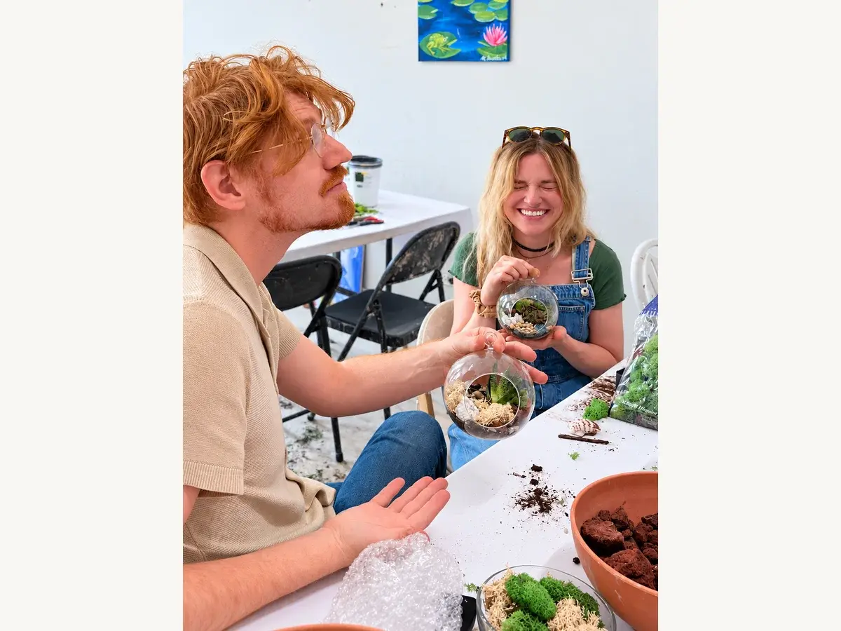 Two guests arranging plants in terrarium containers