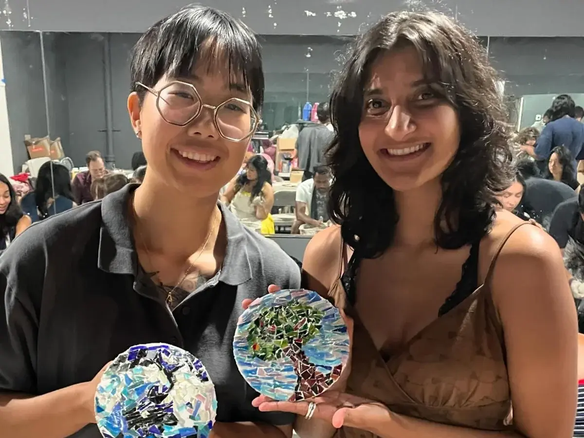 Two guests showing their colorful mosaic creations