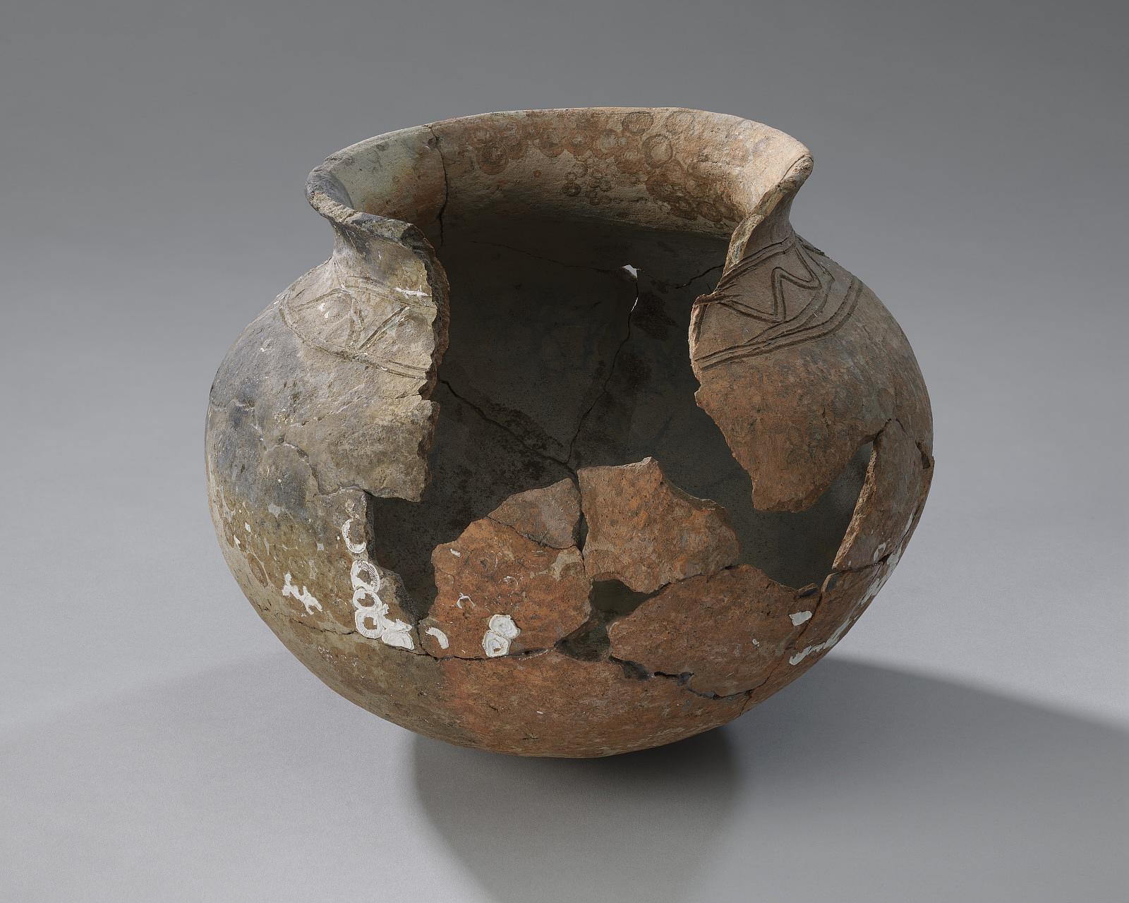 Reconstructed eighteenth-century colonoware pot with incised lines and a missing section, from Cooper River, South Carolina.